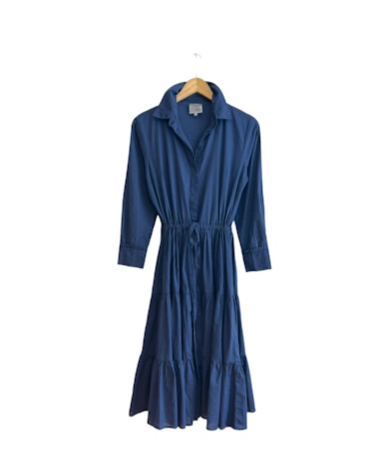 A long-sleeved, navy blue midi dress with a cotton drawstring waist and ruffled hem, displayed on a white background, hanging on a wooden hanger by A Shirt Thing&#39;s Scarlet Cabo.