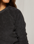 Close-up image of a woman wearing a Perfectwhitetee Saylor Loop Terry Sweatshirt in a bungalow. Only the lower half of her face is visible, highlighting her lips and chin.