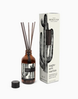 A Faire reed diffuser with a citrus scent in a small brown glass bottle with multiple reeds inserted, next to its packaging labeled "Broken Top Candle Co., SAGUARO CACTUS, Reed Diffuser.