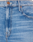 Close-up view of Mother's Maven Ankle Fray denim skirt featuring detailed stitching, front pockets, and bronze-colored button and rivet. The texture of the denim is clearly visible.