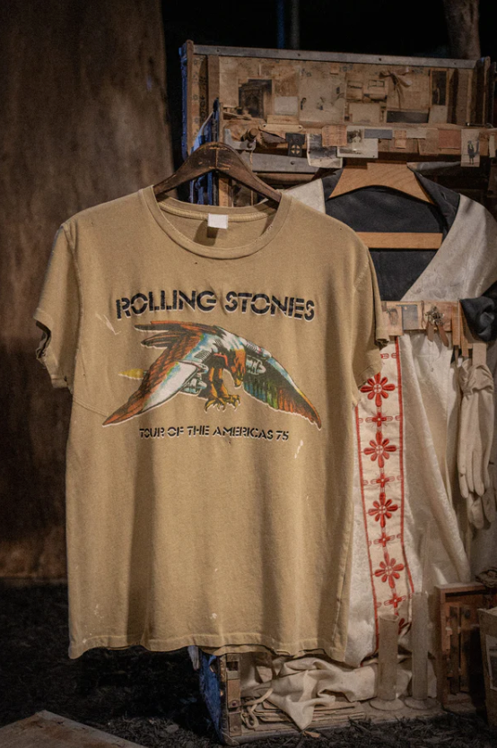 Vintage unisex Made Worn Rolling Stones Americas &#39;75 Tour concert T-shirt, displayed on a wooden frame in a rustic setting with other garments.