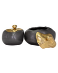 Two Finkle Box decorative ceramic pots with metallic gold details, reminiscent of a Scottsdale Arizona bungalow style; one is completely closed with a round gold lid, and the other is open with a gold accent on the side, all against a white background. (Brand: The Import Collection)