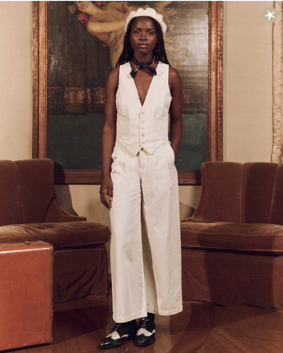 A woman in a white, The Sculpted Trouser-style suit by The Great Inc.