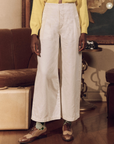 A person wearing stylish white The Sculpted Trouser by The Great Inc.