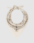 The Great Inc.’s The Silk Bandana, in cream silk with black and gold paisley patterns, is tied in a loose knot and displayed on a plain light gray background.