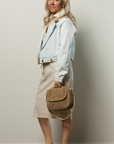 Light summer pencil skirt by Cissa styled with a jacket and woven bag, casual look by a plain wall.