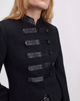 Black blazer with faux leather straps and buttons by Rag & Bone, Mercer Regalia style, shown shoulders up.