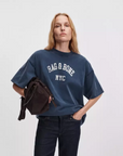 Blue Rag & Bone University Alex tee styled with a dark bag, shown against a plain light background.