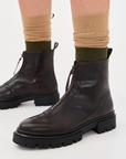 Brown Staud Miles Zip Ankle Boots with chunky soles, styled with green and tan socks on a white background.