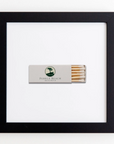 A framed matchbox featuring the logo and name "Pebble Beach Resorts" in the center. The matchbox is white with a stylized tree logo, containing several matches with white tips partially visible from the open end of the box. The black frame has an elegant white background, complementing this unique piece of acrylic art called "Art Square Blk Frame" by Match South.
