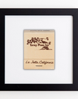A framed matchbook with artwork depicting Torrey Pines Inn from La Jolla, California. The stylized tree and landscape prints are set against a white background and encased in a sleek black frame from Match South's Art Square Blk Frame collection.