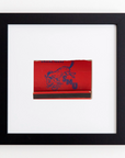 A framed artwork featuring a vintage red matchbook from Dallas, Texas, with a blue illustration of a galloping horse and the letters "SMU" in blue. The matchbook is centered on a white background and enclosed in an elegant black acrylic frame called the Art Square Blk Frame by Match South.