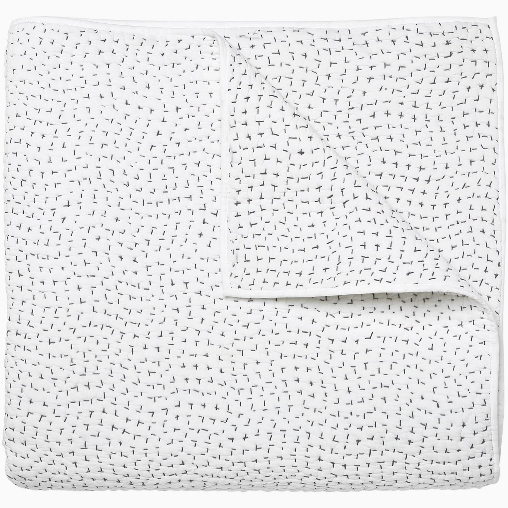 The John Robshaw Coverlet Queen features a hand-stitched white design with subtle black details and is folded neatly to show its reversible bedding style.
