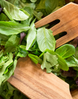 A wooden salad bowl with fresh mixed greens, paired with the Fox Run Brands Acacia Utensil Set crafted from durable Acacia hardwood.