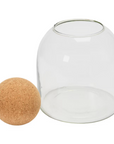 The Bloomingville Glass Jar Cork Ball features a round glass jar with an open top and a large spherical cork lid, ideal for decorative storage. This stylish set is displayed against a crisp white background.