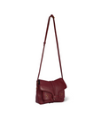 The Harry Handbag by Jerome Dreyfuss is a burgundy leather crossbody bag with an adjustable strap, front flap closure, and subtle stitching details on the front pockets.