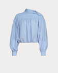 The Parachute Top by Rachel Comey is a light blue, wrinkle-resistant, long-sleeve blouse with a high neckline, gathered yoke, puffed sleeves, fitted cuffs, an asymmetrical neck bow, and an elasticized cropped hem—ideal for stylish travel.