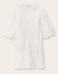 Dress Malo by BA&SH is a white short-sleeve blouse made from organic cotton, featuring a geometric broderie anglaise pattern, V-neckline, and scalloped edges on sleeves and hem. The lightweight fabric is slightly sheer.