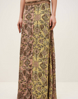 A person wears the BA&SH Skirt Pario, a flared midi skirt featuring intricate vintage-inspired geometric and floral patterns in muted yellow, pink, and brown tones, standing against a plain light background.