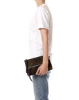 Jerome Dreyfuss Lucky Clutch L with zip closure, held by person in white tee and jeans against a white backdrop.