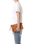 Jerome Dreyfuss Lucky Clutch L in hand, styled with casual white tee and jeans against a minimalist backdrop.