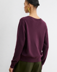 Rachel Comey Slate Pullover in slate gray paired with green pants, styled with gold hoop earrings and hair tied back.
