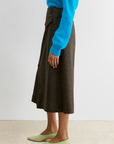 Rachel Comey Montrose Skirt styled with a blue sweater and light green heels on a beige carpet.