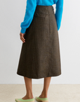 Rachel Comey Montrose Skirt in blue, styled with blue sweater and green low-heel shoes, back view.