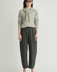 Apiece Apart Spa Pleat Pant in Rosin paired with an organic sweater, styled with brown shoes.