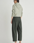 Apiece Apart Spa Pleat Pant styled with a light hoodie, shown from the back against a simple backdrop.