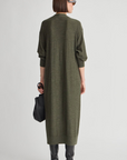 Apiece Apart Drippy Cardi Dress in a relaxed fit, paired with black boots and bag, model facing away.