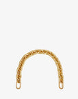 The Clare Vivier Shortie Strap S24 is a short, thick gold resin chain with large interlocking links and elongated ovals at each end for easy bag attachment, shown gracefully arched against a plain white background.