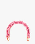 The Clare Vivier Shortie Strap Q1 is a chunky pink plastic bag handle with gold-tone clasps at each end, evoking a vintage chain style and shown on a white background.