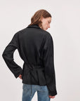 Rag & Bone sonny silk blouse paired with black satin jacket and blue jeans, model standing with hand on hip.