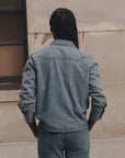 Lightweight denim Howdy Top by The Great Inc. with pearl snaps, seen from the back on a person with long braids.