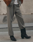 The Great Inc. Fleece Sport Sweatpant in a casual street style, paired with black boots and a brown jacket on sidewalk.