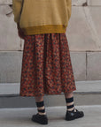 Yellow The Canary Skirt by The Great Inc. styled with a matching sweater and striped socks on concrete.