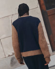 Navy and brown Wellington Card by The Great Inc. styled outdoors, model with braids shown from the back.