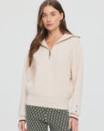 The Upside KAIRO HALF ZIP KNIT sweater with patterned pants, styled against a minimal light background.