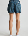 Denimist Utility Short in rigid indigo denim, shown from the back, paired with white shoes on a plain background.