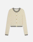 The FRAME The Rookie Cardi is a cream long-sleeve cardigan in lightweight knit with a diamond openwork texture, gold buttons, and black striped trim on the round neck, cuffs, and hem.