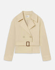 The Uniform Trench by FRAME is a tailored beige cropped double-breasted jacket with a notched collar, long sleeves, button-and-belt closure, and a matching square-buckle waist belt, shown laid flat on a white background.