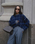 White + Warren cashmere windowpane sweatshirt in stone setting, styled with gray handbag, casual modern look.
