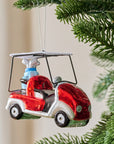 The Creative Co-op Glass Golf Cart Ornament, shaped like a red and white cart with a silver roof and a blue present in the back seat, is perfect for golf fans and makes a festive addition to your Christmas tree.