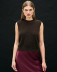 A woman with straight, light brown hair wears the Jumper 1 2 3 4/CR2 Distressed Tank, a sleeveless dark brown top, and a burgundy skirt, standing against a plain black background, looking directly at the camera with a neutral expression.