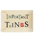 The Important Things Glass Tray by Faire is a rectangular handcrafted découpaged piece from New York, featuring black, green, and red vintage lettering with a bold red "G" in "THINGS.