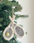 Faire’s Felted Ornament features two crossed tennis rackets and a small yellow ball, making it the perfect sporty touch for your Christmas tree.