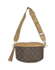 A brown Faire Upcycled Belt Bag in canvas with tan leather trim, wide adjustable strap, gold hardware, and a tassel zipper pull. This chic designer bag features a signature LV-style monogram pattern for timeless style.