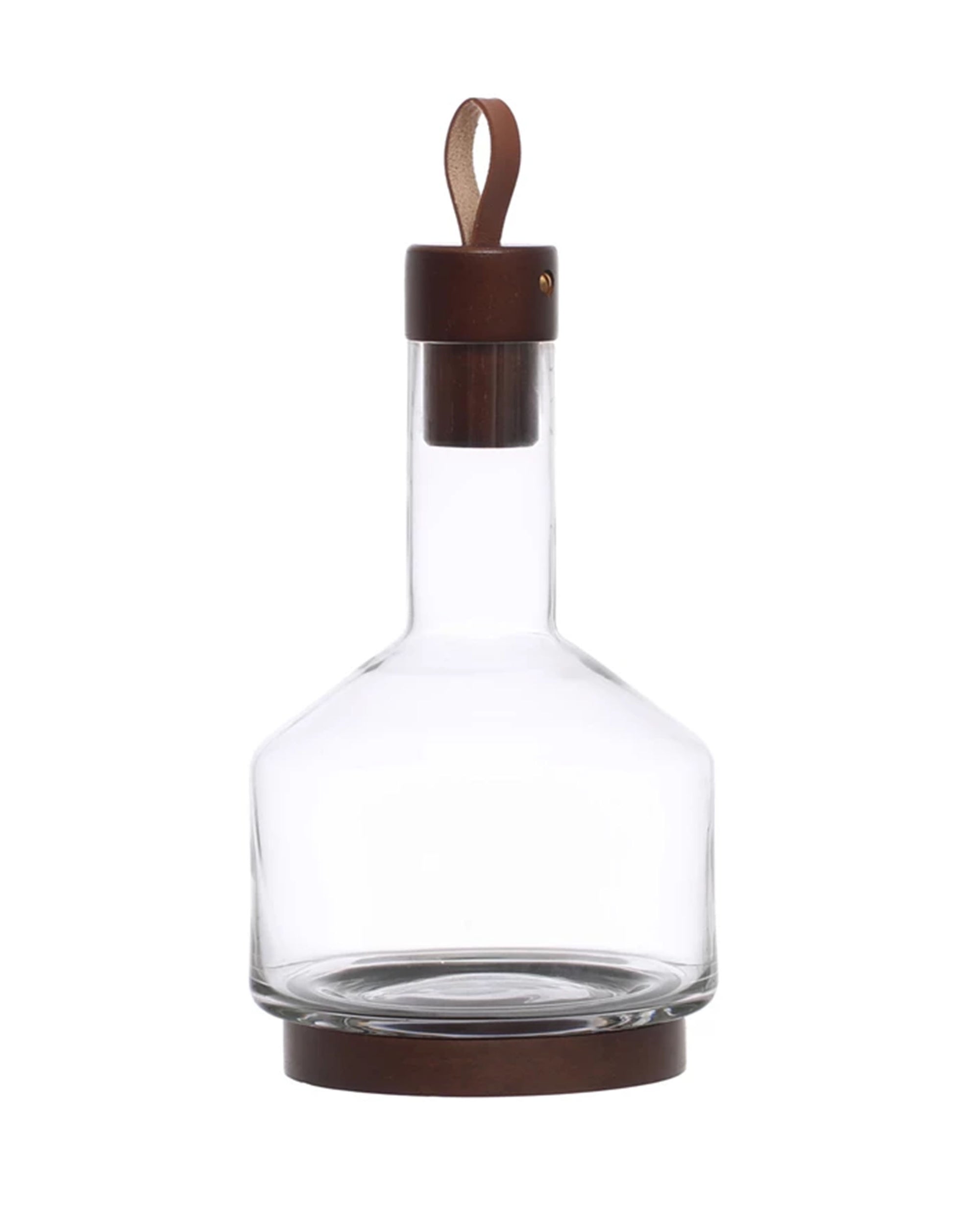 The Bloomingville Carafe w/ Acacia Wood Base features a clear glass body, wide base, narrow neck, and a dark acacia stopper with a tan leather loop, plus a matching wood band, making it an elegant addition to your serveware.
