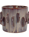 A ceramic mug with a unique design, featuring raised, petal-like patterns inspired by Scottsdale Arizona landscapes around its surface. It has a glossy, dark brown finish with slight dripping effects from Bloomingville.